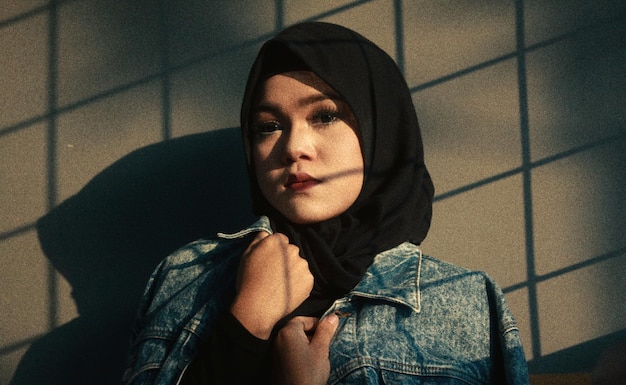 Retrato de uma jovem vestindo hijab contra a parede durante o pôr do sol
