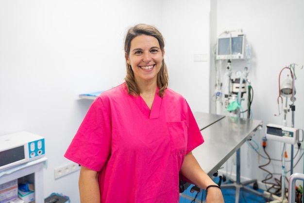 Retrato de uma jovem veterinária na clínica veterinária sorrindo de uniforme