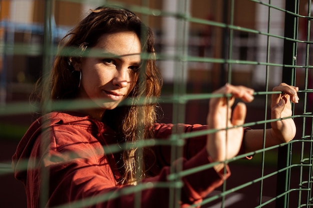 Foto retrato de uma jovem vista através de uma cerca