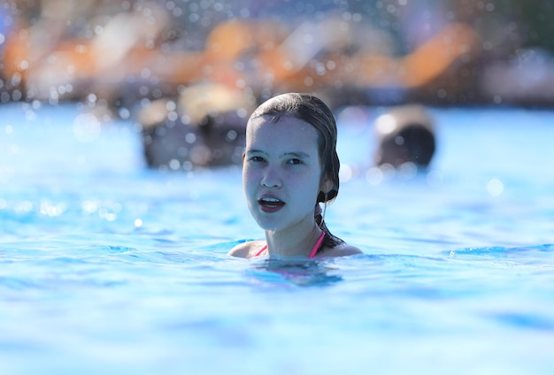 retrato de uma linda adolescente nada na piscina