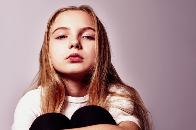 Foto retrato de uma linda adolescente pensativa com cabelo comprido.