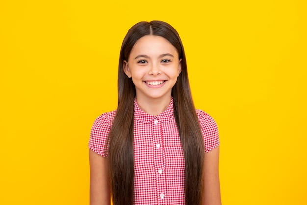 Retrato de uma linda adolescente sorridente feliz no fundo amarelo do estúdio