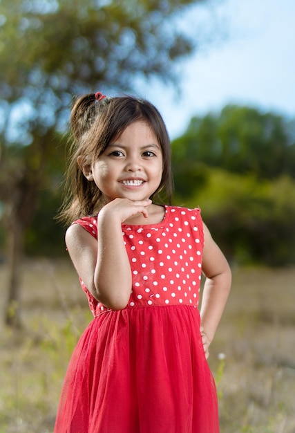 Foto retrato de uma linda criança no fundo do parque de verão
