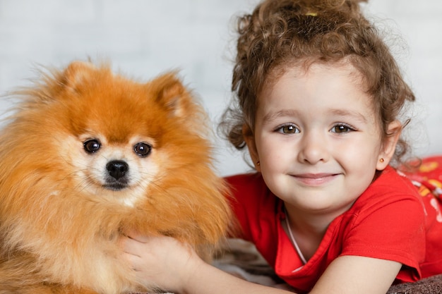 Retrato de uma linda criança posando com seu cachorro