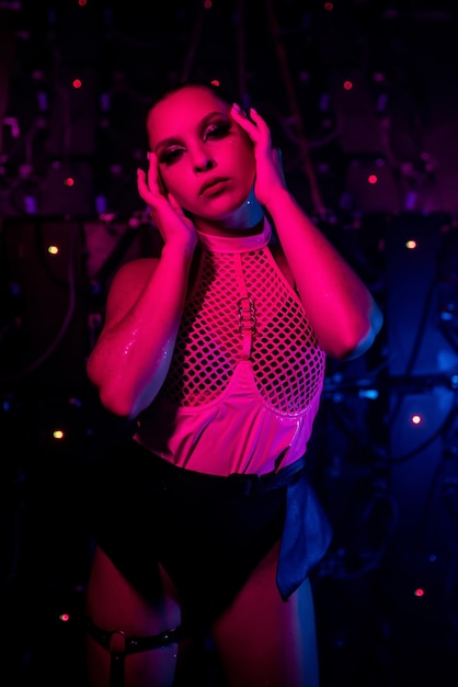Retrato de uma linda dançarina gogo posando em uma boate Iluminação atmosférica rosa Boate conceito de festa