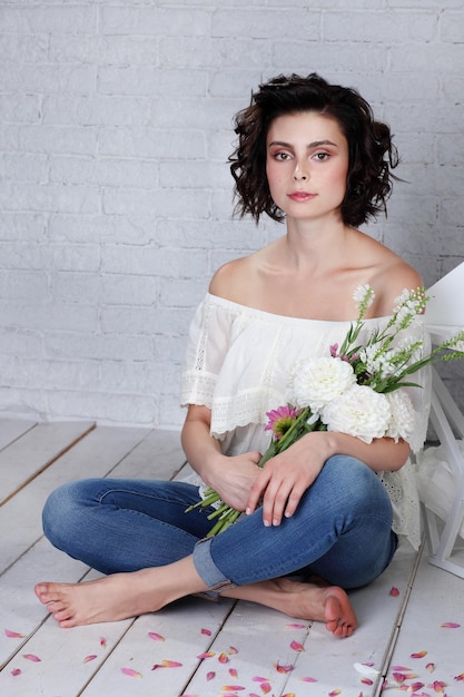 Retrato de uma linda e modesta garota muito fofa com um buquê de flores no Studio closeup