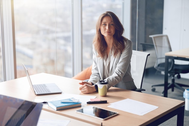 Foto retrato de uma linda empresária confiante trabalhando em um escritório moderno