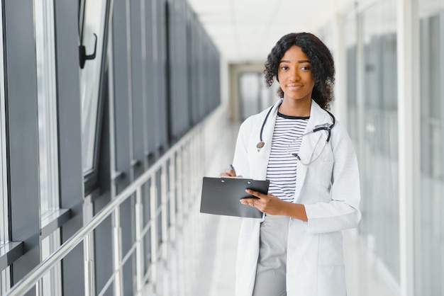 Retrato de uma linda estagiária de medicina afro-americana em um escritório moderno