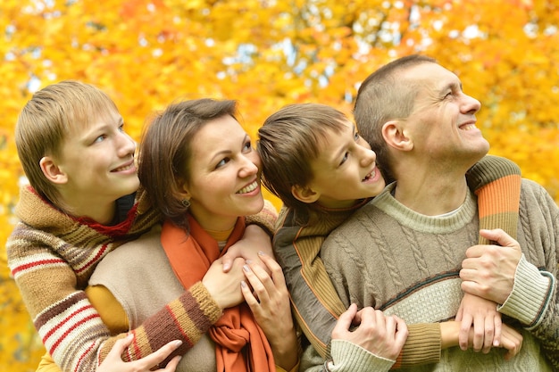 Retrato de uma linda família feliz deitada no parque outono