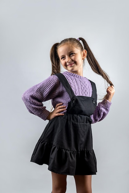 Retrato de uma linda garota alegre e confiante isolada em um fundo de estúdio típico