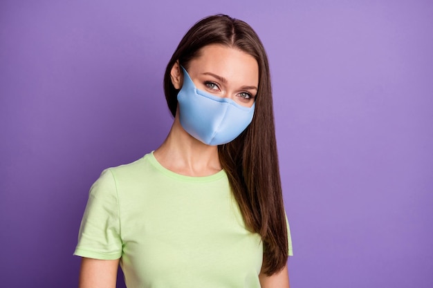 Retrato de uma linda garota alegre usando uma máscara de camiseta verde isolada sobre um fundo de cor violeta lilás vibrante brilho vívido brilhante