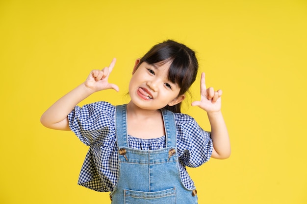 Retrato de uma linda garota asiática isolada em fundo amarelo