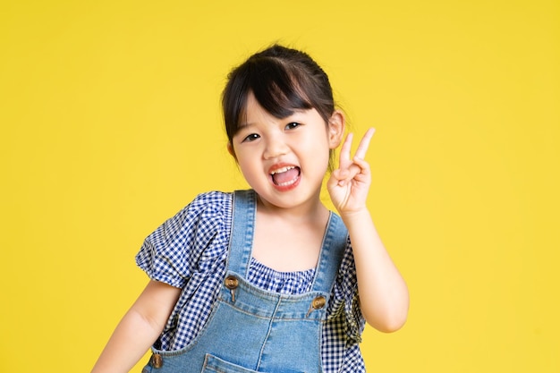 Retrato de uma linda garota asiática isolada em fundo amarelo