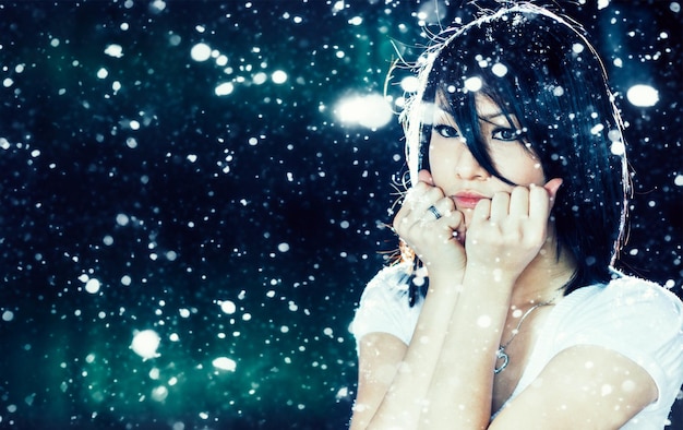 Retrato de uma linda garota asiática sob a neve