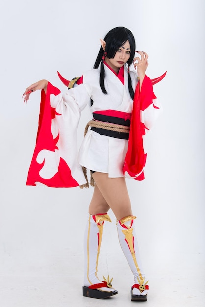 Retrato de uma linda garota asiática usa animação de jogo cosplay em fundo brancoTailândia pessoas Panos vermelhos estilo diabo