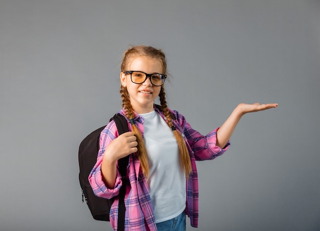 Retrato de uma linda garota atraente alegre alegre contente, colegial esticando a palma da mão para a frente