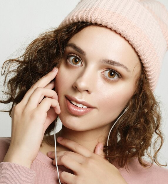 Retrato de uma linda garota em fones de ouvido ouve música