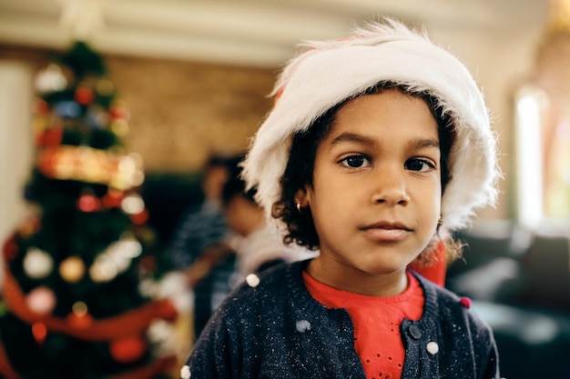 Retrato de uma linda garota negra usando chapéu de Papai Noel no Natal