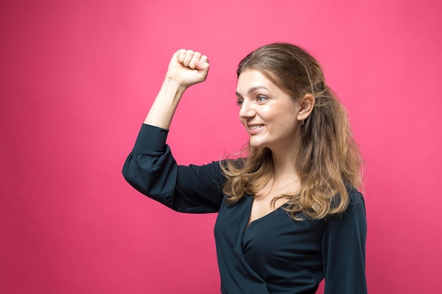 Retrato de uma linda garota olha de lado com expressão pensativa está considerando um plano para mais ações em um fundo rosa