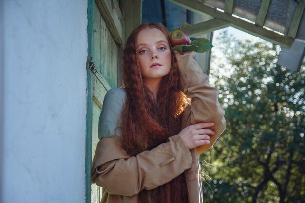 Foto retrato de uma linda garota ruiva com cabelo comprido e maçãs no outono