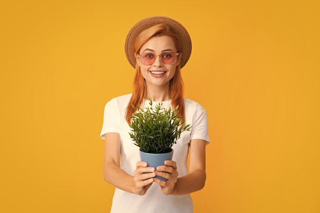 Retrato de uma linda garota segura potes com broto exótico Linda senhora com roupa de jardinagem sorrindo