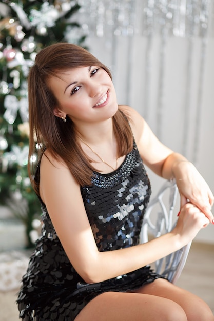 Retrato de uma linda garota sorridente em elegantes decorações de Natal