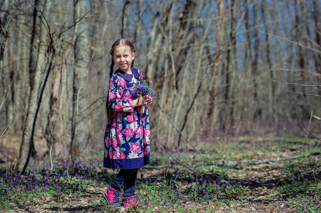 Retrato de uma linda garotinha com flores corydalis