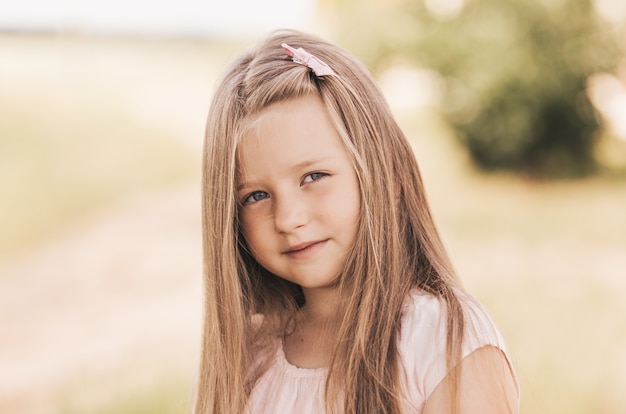 Retrato de uma linda garotinha loira em um campo de trigo