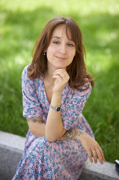 retrato de uma linda jovem caucasiana com cabelo encaracolado em um lindo vestido no parque closeup