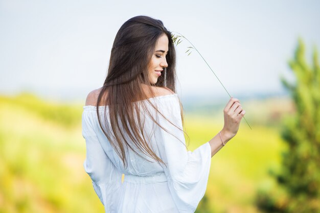 Retrato de uma linda jovem com espigão, ao ar livre, no campo