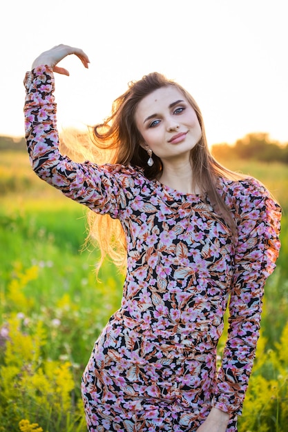 Retrato de uma linda jovem em um vestido colorido, ao ar livre, no campo