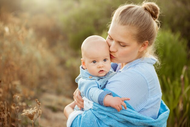 Retrato de uma linda jovem mãe segurando seu filho bebê