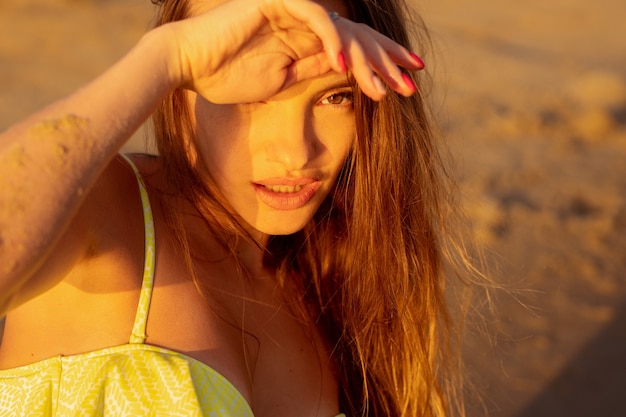 Foto retrato de uma linda jovem no mar ao pôr do sol