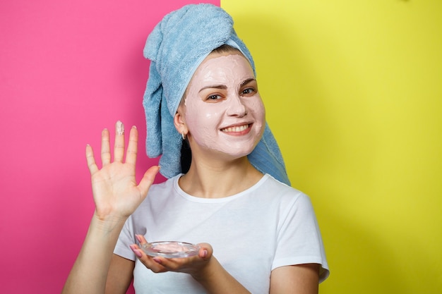 Retrato de uma linda jovem que coloca uma máscara refrescante no rosto para rejuvenescer e tonificar a pele. Tratamentos de beleza