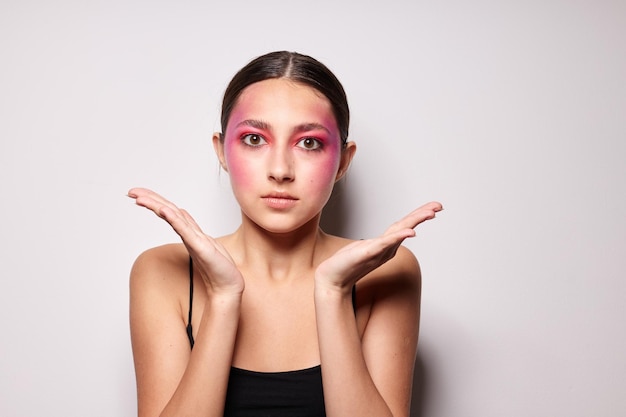 Retrato de uma linda jovem sorri maquiagem rosa brilhante emoções cosméticos visão recortada inalterada