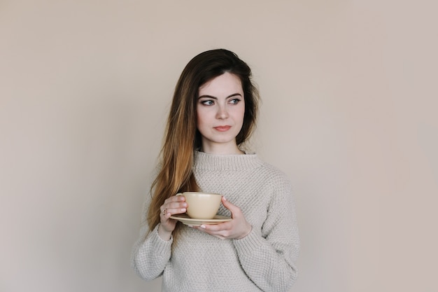 Retrato de uma linda jovem tomando café