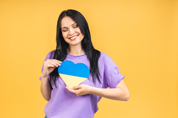 Retrato de uma linda linda e alegre mulher segurando em mãos a bandeira ucraniana se divertindo