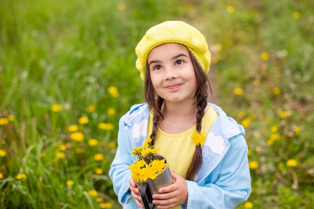 Retrato de uma linda menina com duas tranças segurando um buquê de flores amarelas