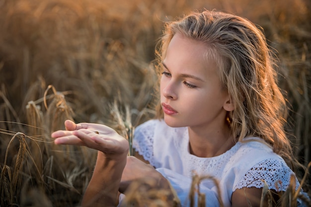 Retrato de uma linda menina criança em um campo no verão