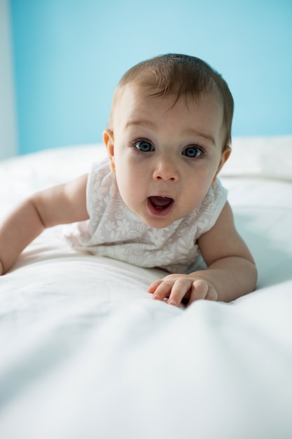 Retrato de uma linda menina deitada na cama no quarto