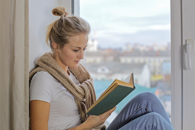 Retrato de uma linda menina europeia que lê um livro