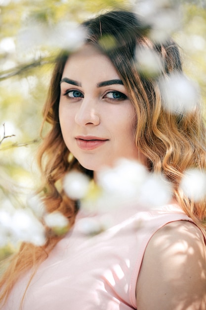 Retrato de uma linda menina loira no bokeh de flor.