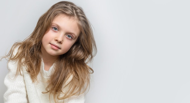 Retrato de uma linda menina sorridente feliz em um fundo branco, banner. copie o espaço para o texto