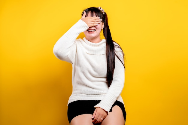 Retrato de uma linda mulher asiática com um rosto sorridente. Mulher asiática, vestindo roupas casuais. Estilo de vida tailandês. Sorriso brilhante de garota fofa em um fundo amarelo