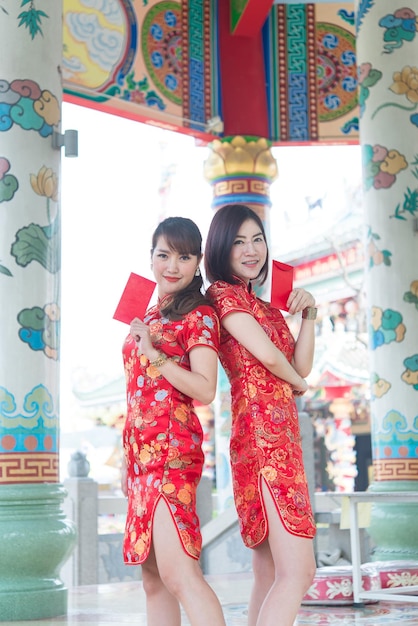 Retrato de uma linda mulher asiática no vestido Cheongsam com envelope vermelho na mãoTailândia pessoasFeliz conceito de ano novo chinês