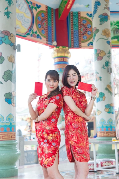Retrato de uma linda mulher asiática no vestido Cheongsam com envelope vermelho na mãoTailândia pessoasFeliz conceito de ano novo chinês