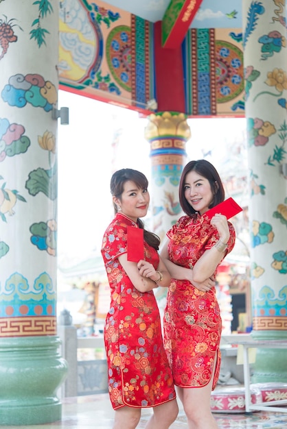 Retrato de uma linda mulher asiática no vestido Cheongsam com envelope vermelho na mãoTailândia pessoasFeliz conceito de ano novo chinês