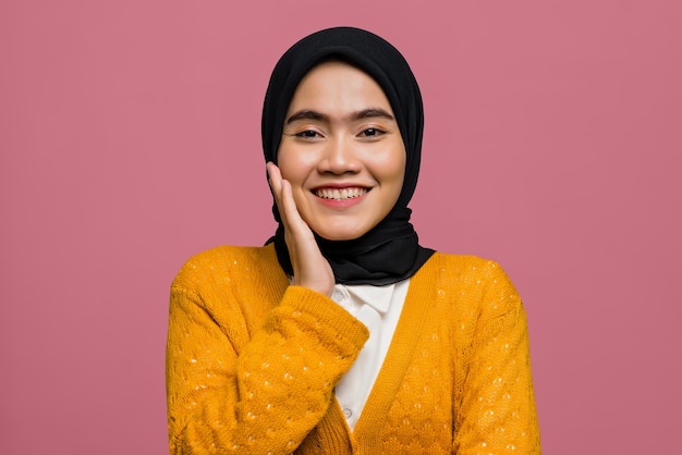 Retrato de uma linda mulher asiática sorrindo e vestindo um casaco de lã amarelo