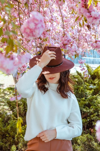 Retrato de uma linda mulher caucasiana com cerejeiras sakura florescendo copiam o espaço