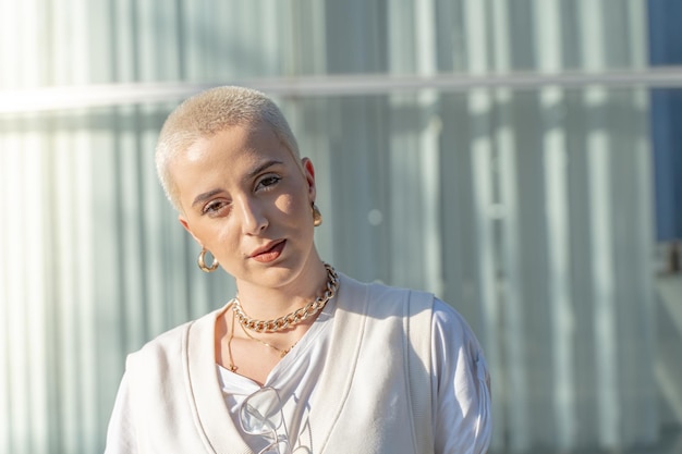 Retrato de uma linda mulher caucasiana, olhando para a câmera de cabelo curto e branco no campus do estudante